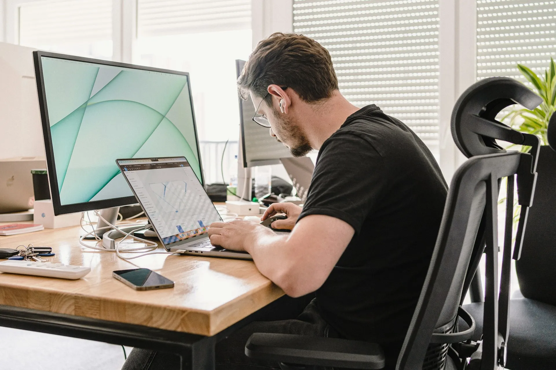 Professional working with multiple digital devices in a modern workspace