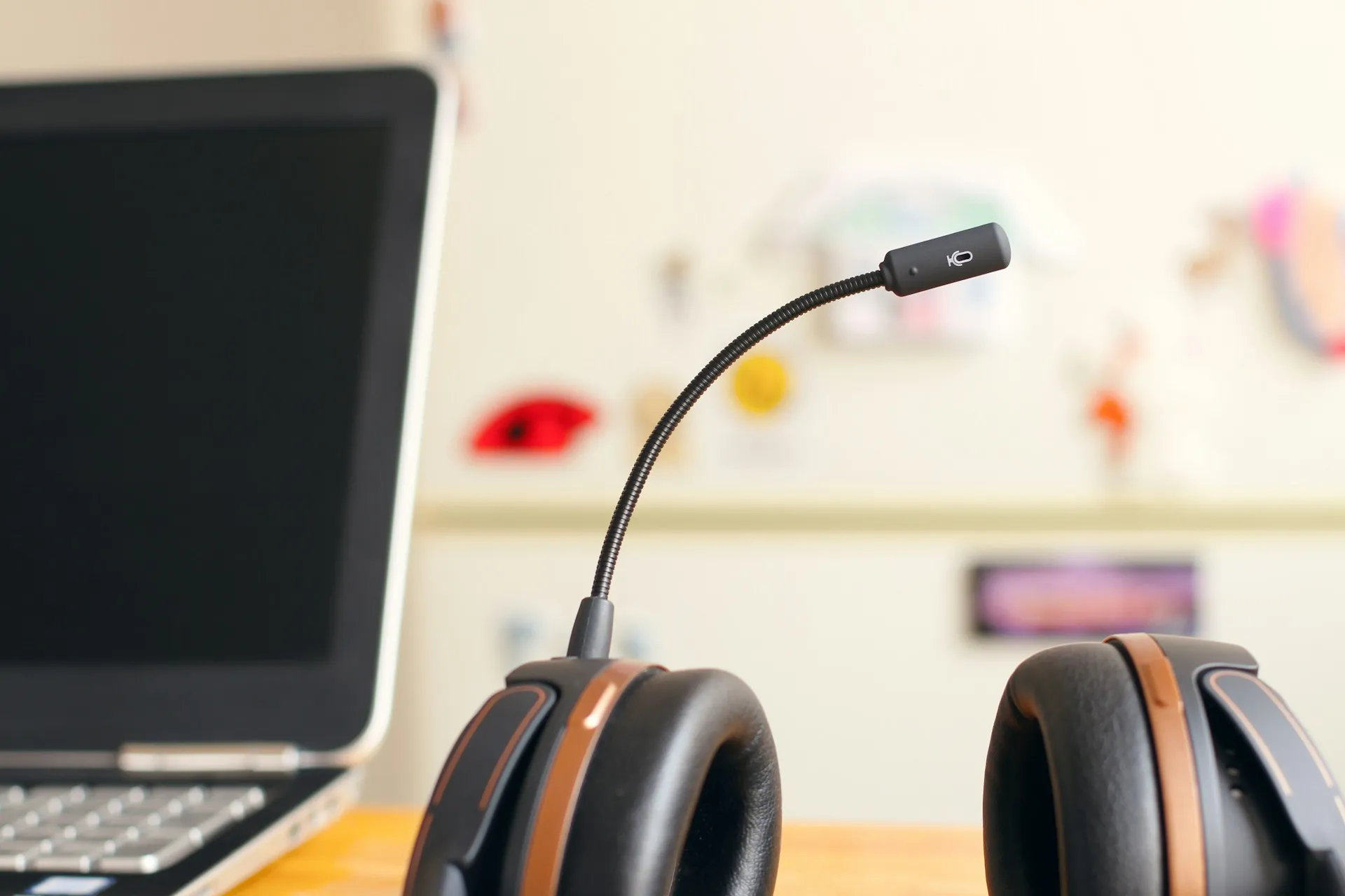 A professional headset with microphone next to a laptop