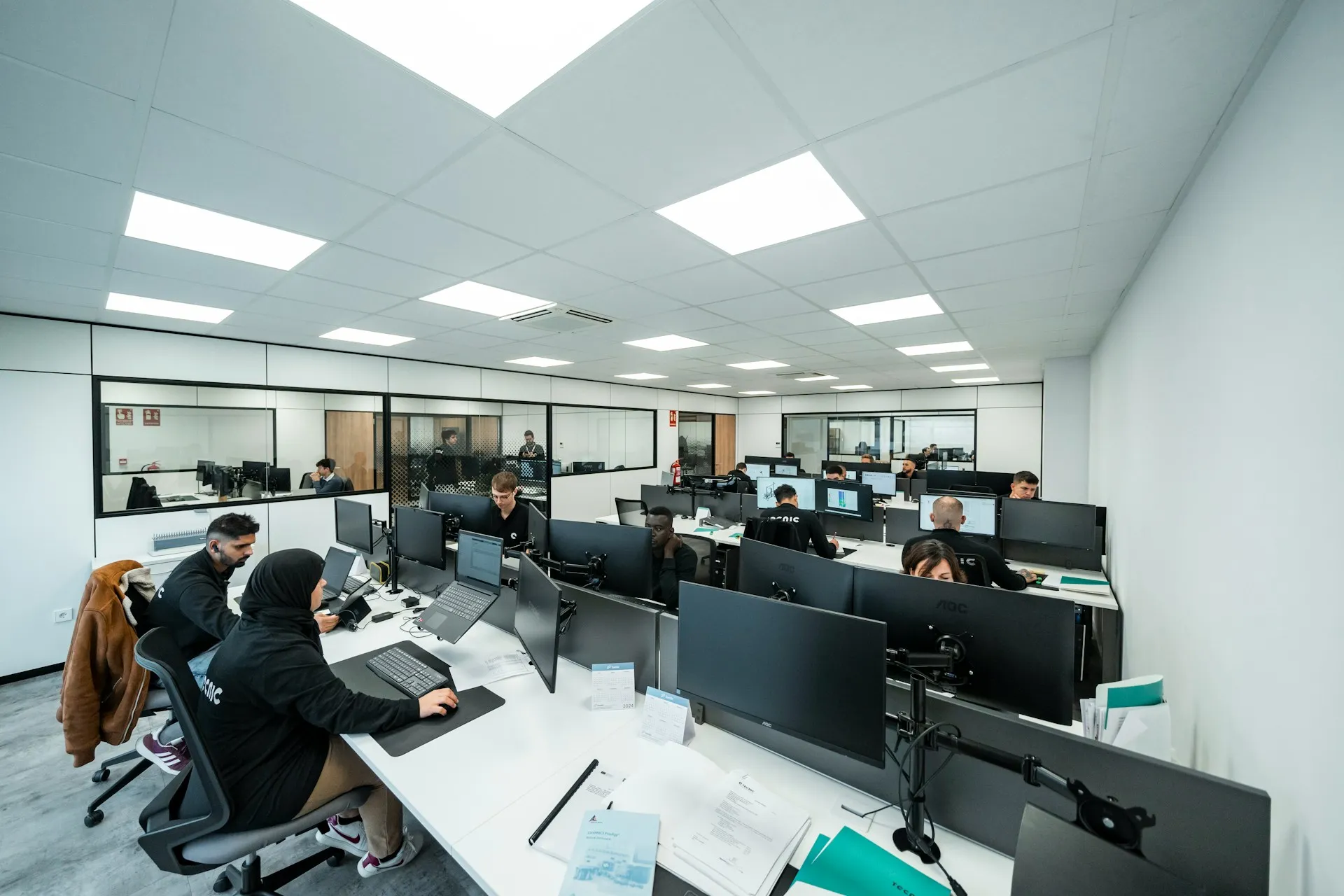 Modern technology office with teams working at computer workstations