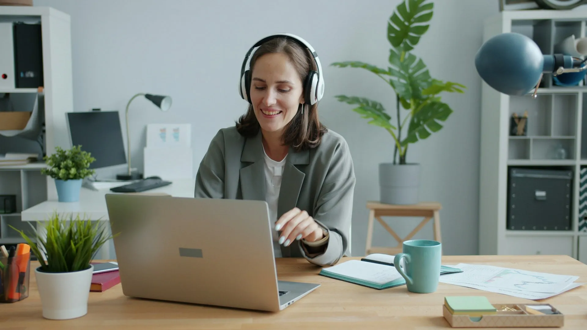 Woman wearing headphones attending an online session on a laptop
