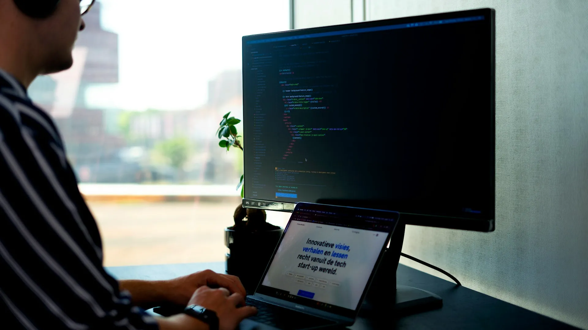 Software developer working on code using a computer in a modern workspace.